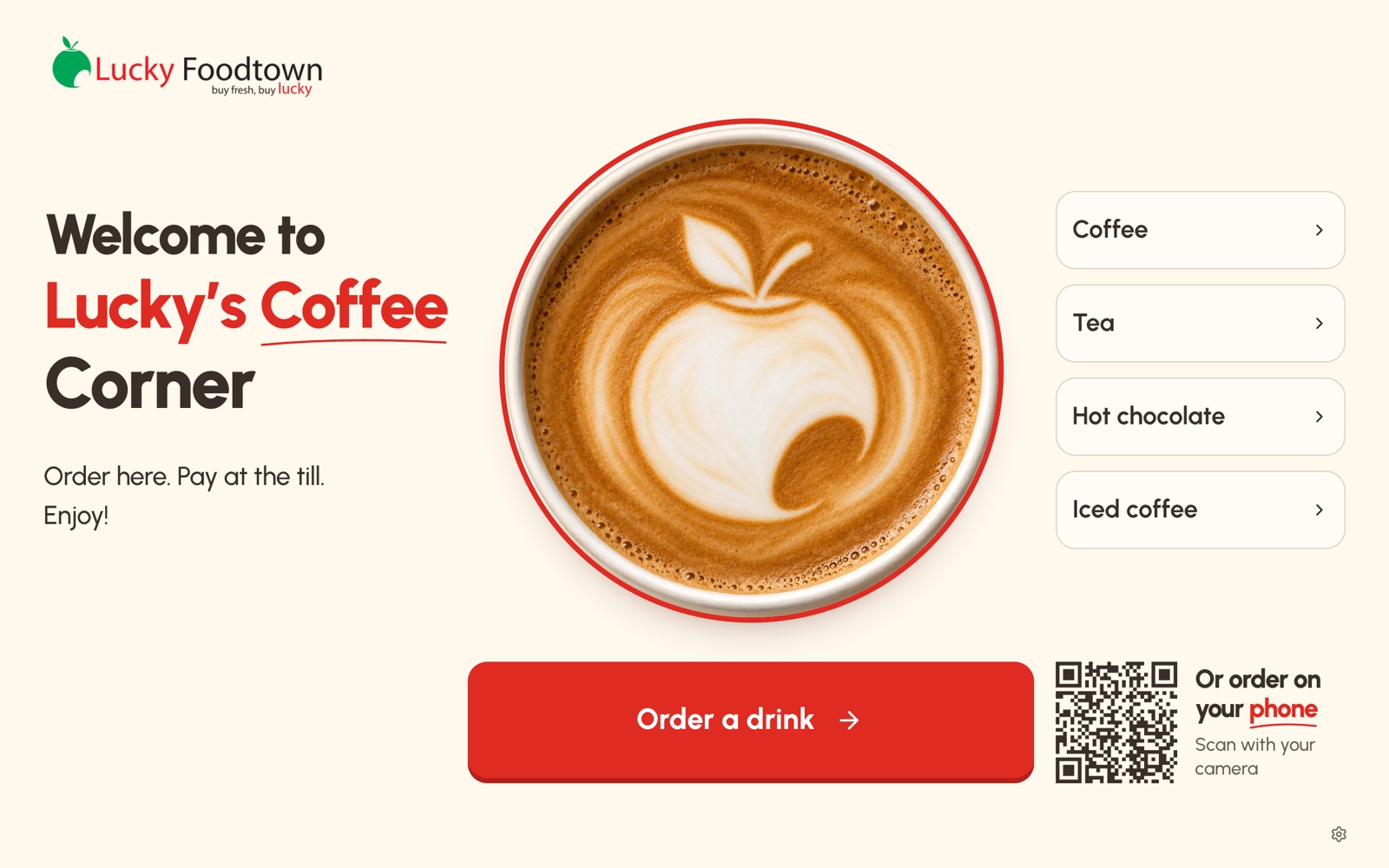 The welcome screen on the tablet at Lucky Foodtown's coffee counter. It reads: Welcome to Lucky's Coffee Corner. Order here. Pay at the till. Enjoy! Beside a cup of coffee are buttons for coffee, tea, hot chocolate and iced coffee, an Order a drink button, and a QR code to order on your phone.